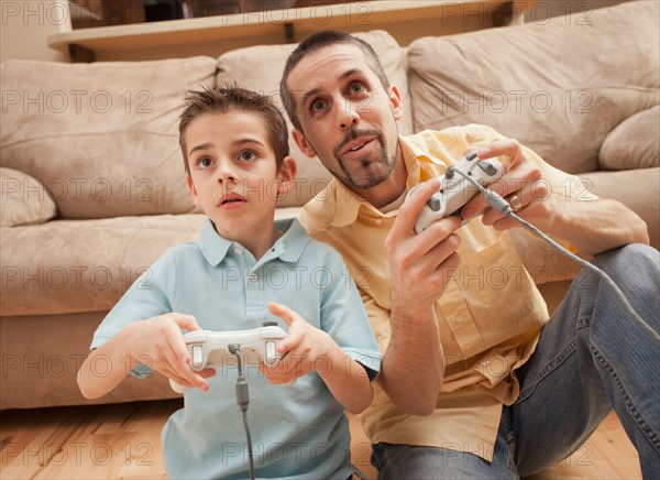 Front view of father and son (8-9) playing Video Games. Photo : Mike Kemp