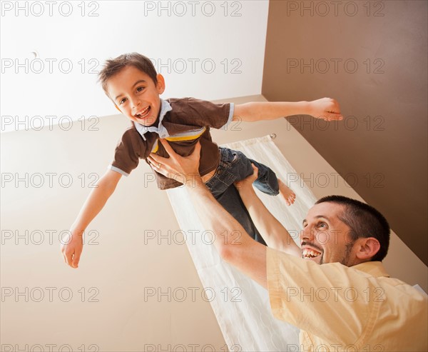 Father holding aloft his son (6-7). Photo : Mike Kemp