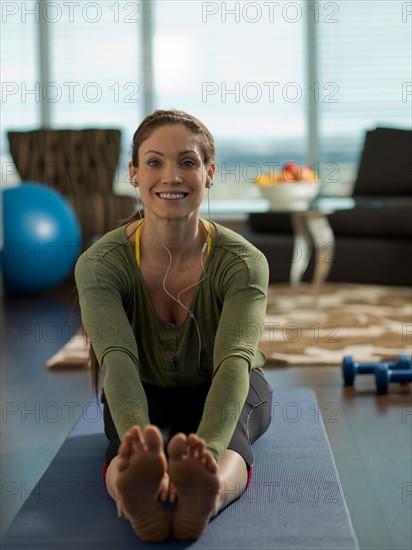 Portrait of mid adult woman exercising at home. Photo : Dan Bannister