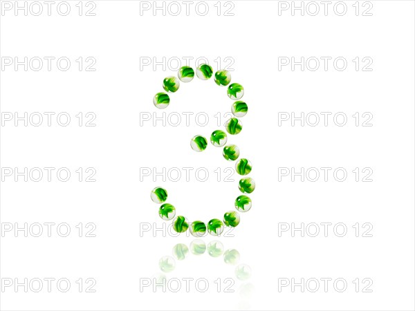 Studio shot of green marbles arranged in Exclamation Point. Photo : David Arky