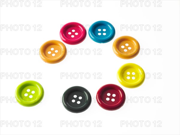 Studio shot of multi colored buttons arranged in circle. Photo : David Arky