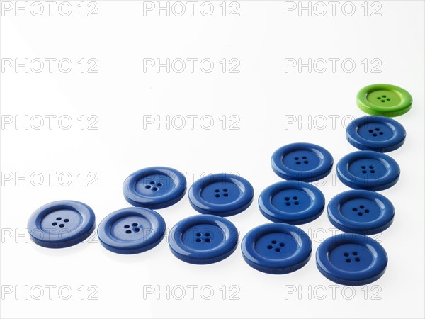 Studio shot of blue and green buttons in a row. Photo : David Arky