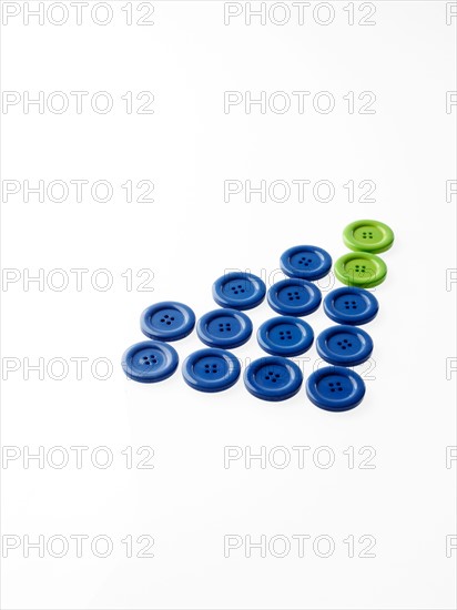 Studio shot of blue and green buttons in a row. Photo : David Arky