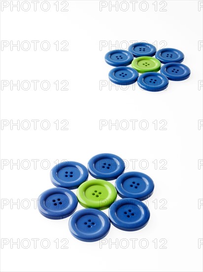 Studio shot of blue and green buttons arranged in flower head. Photo : David Arky