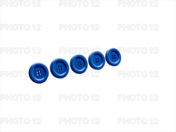 Studio shot of blue buttons in a row. Photo : David Arky