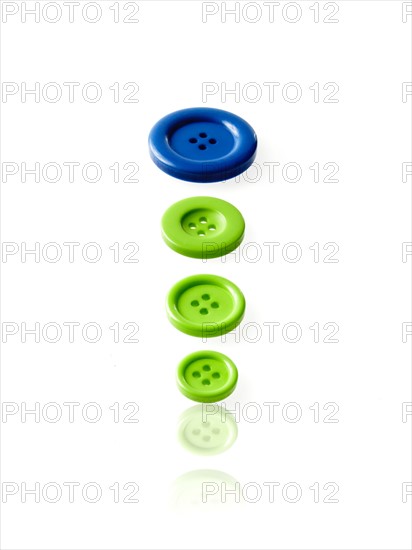 Studio shot of blue and green buttons in a row. Photo : David Arky
