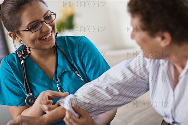 Young female nurse attending patient. Photo : Tim Pannell