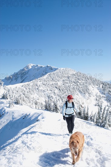 USA, Montana, Bob Marshall Wilderness, Mt.Aeneus. Woman hiking with her dog in winter scenery. Photo : Noah Clayton