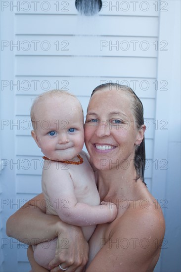 Mid adult woman having shower with her baby son (12-17 months) . Photo : Noah Clayton