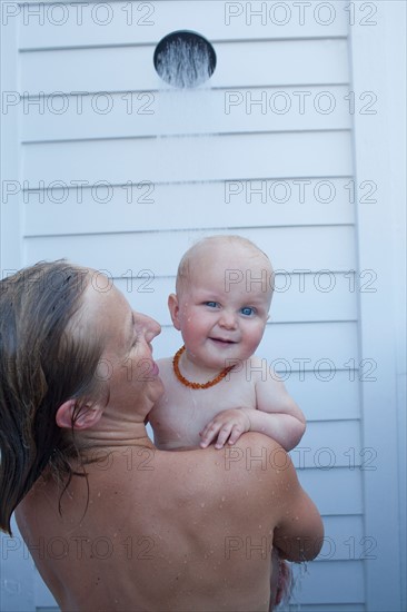 Mid adult woman having shower with her baby son (12-17 months) . Photo : Noah Clayton