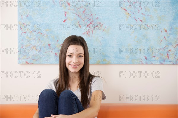 Portrait of smiling woman sitting on sofa. Photo : Rob Lewine