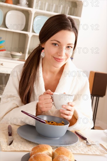 Young smiling woman at breakfast. Photo : Rob Lewine