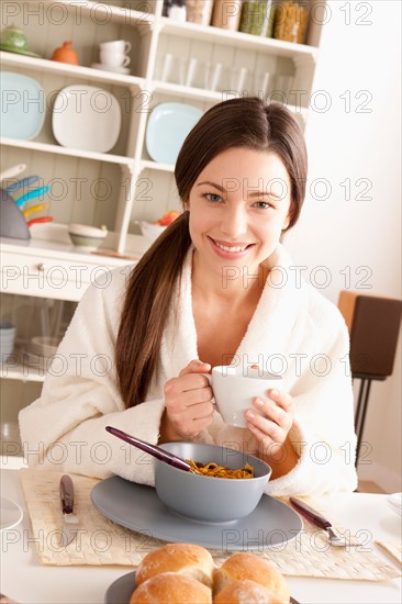 Young smiling woman at breakfast. Photo : Rob Lewine