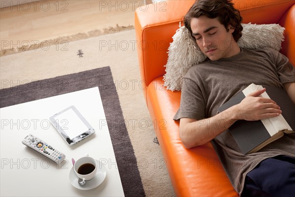 Young man sleeping on sofa. Photo : Rob Lewine