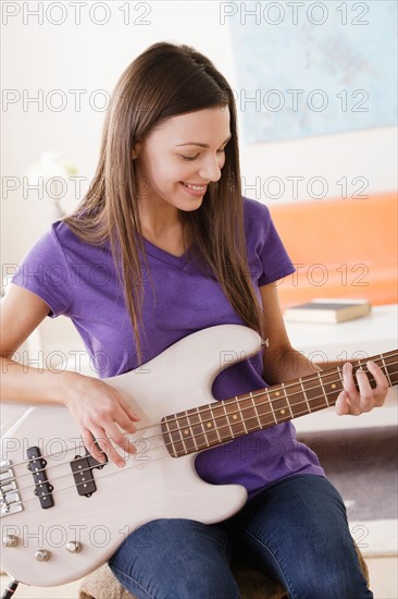 Young woman playing electric guitar. Photo : Rob Lewine