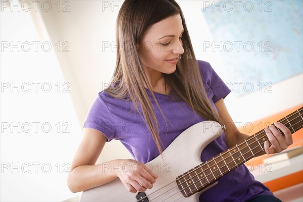 Young woman playing electric guitar. Photo : Rob Lewine