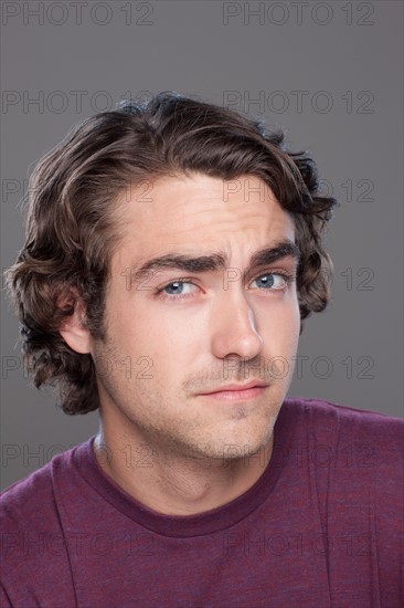 Studio shot of young man frowning forehead. Photo : Rob Lewine