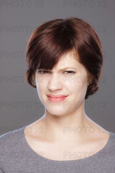 Studio shot of confused young woman. Photo : Rob Lewine