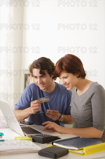 Young couple using laptop . Photo : Rob Lewine