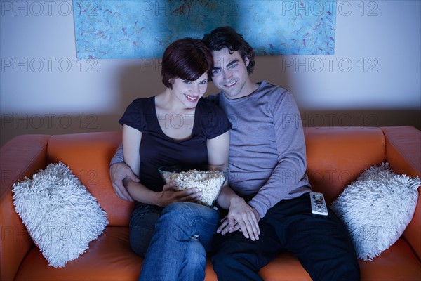 Young couple watching TV. Photo : Rob Lewine