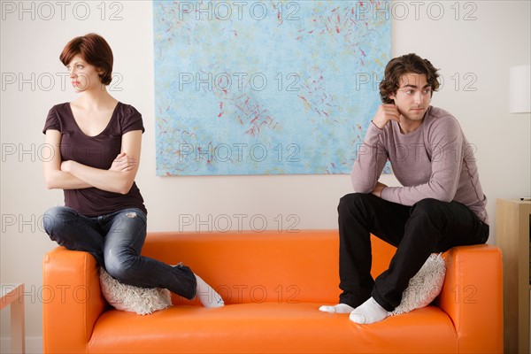 Young couple sitting on sofa . Photo : Rob Lewine