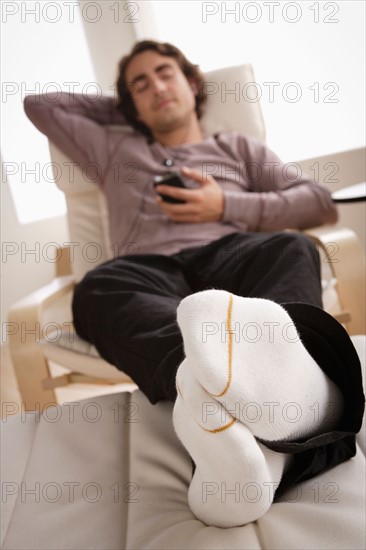 Young man listening music on armchair. Photo : Rob Lewine