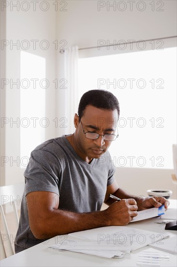 Mature man using calculator. Photo : Rob Lewine