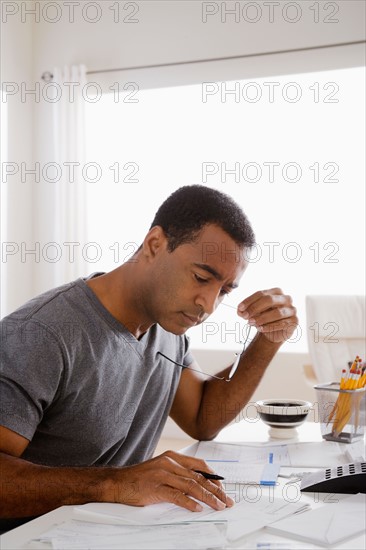 Mature man using calculator. Photo : Rob Lewine