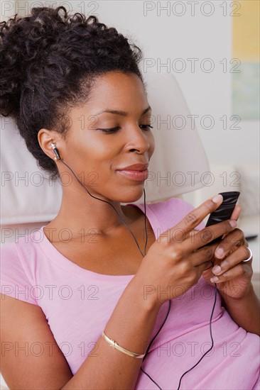 Young smiling woman listening music. Photo : Rob Lewine