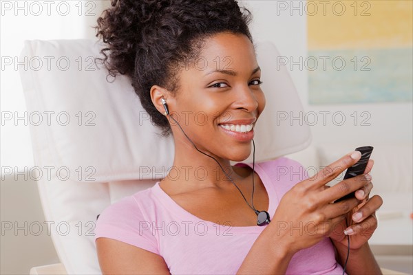 Young smiling woman listening music. Photo : Rob Lewine