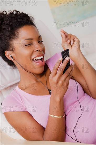 Young smiling woman listening music. Photo : Rob Lewine