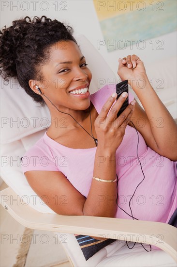 Young smiling woman listening music. Photo : Rob Lewine