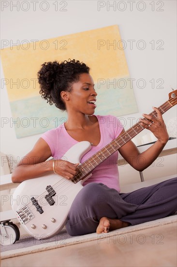 Young woman playing electric guitar. Photo : Rob Lewine