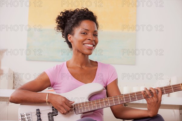 Young woman playing electric guitar. Photo : Rob Lewine