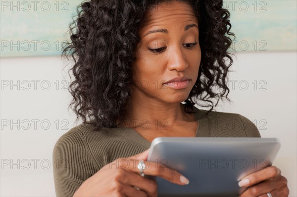 Mid adult woman using digital tablet. Photo : Rob Lewine