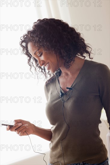 Mid adult woman listening music. Photo : Rob Lewine