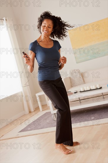 Mid adult woman dancing at home. Photo : Rob Lewine