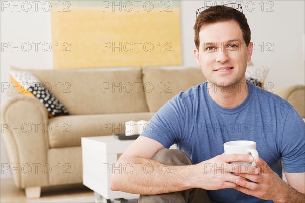 Portrait of smiling mid adult man holding mug. Photo : Rob Lewine