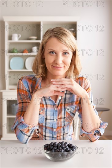 Portrait of mid adult woman with bowl of grapes. Photo : Rob Lewine