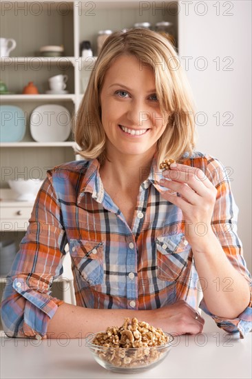 Portrait of mid adult woman with bowl of walnuts. Photo : Rob Lewine