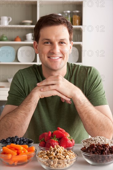 Portrait of mid adult man with healthy fruits. Photo : Rob Lewine