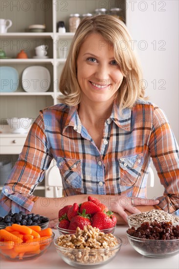 Portrait of mid adult woman with healthy fruits. Photo : Rob Lewine
