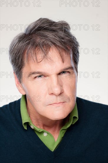 Studio portrait of mature man with facial expression. Photo : Rob Lewine