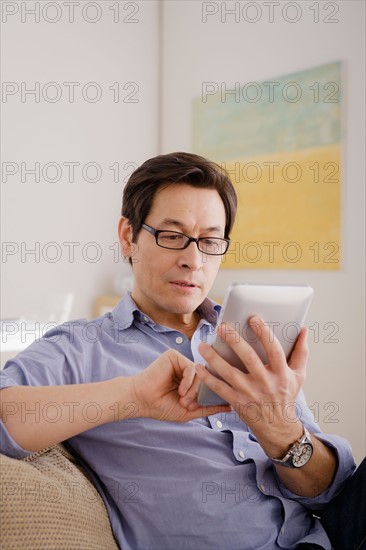 Man reading e-book at home. Photo : Rob Lewine