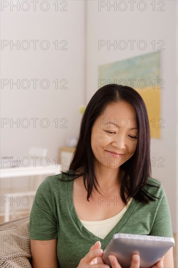 Woman reading e-book at home. Photo : Rob Lewine