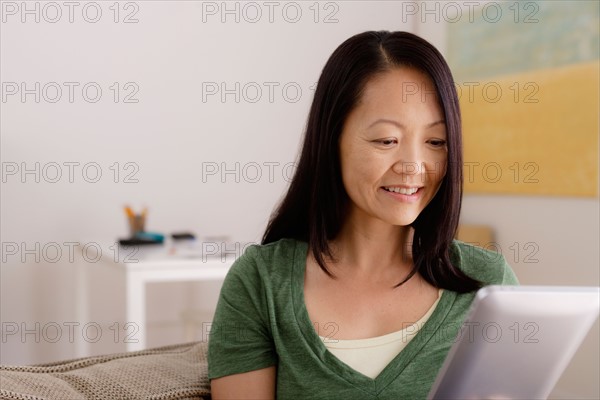 Woman reading e-book at home. Photo : Rob Lewine