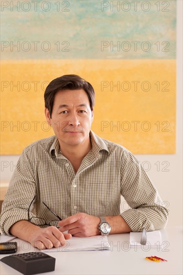 Portrait of man doing paperwork. Photo : Rob Lewine