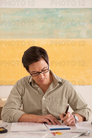 Man doing paperwork. Photo : Rob Lewine