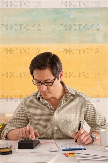Man doing paperwork. Photo : Rob Lewine