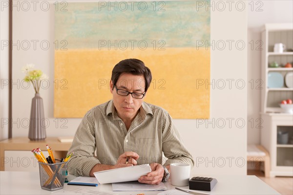 Man doing paperwork. Photo : Rob Lewine